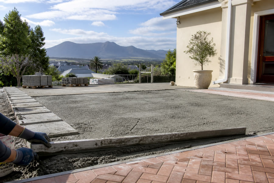 Light-grey concrete pavers being screeded beside terracotta herringbone at a Durbanville suburban home.